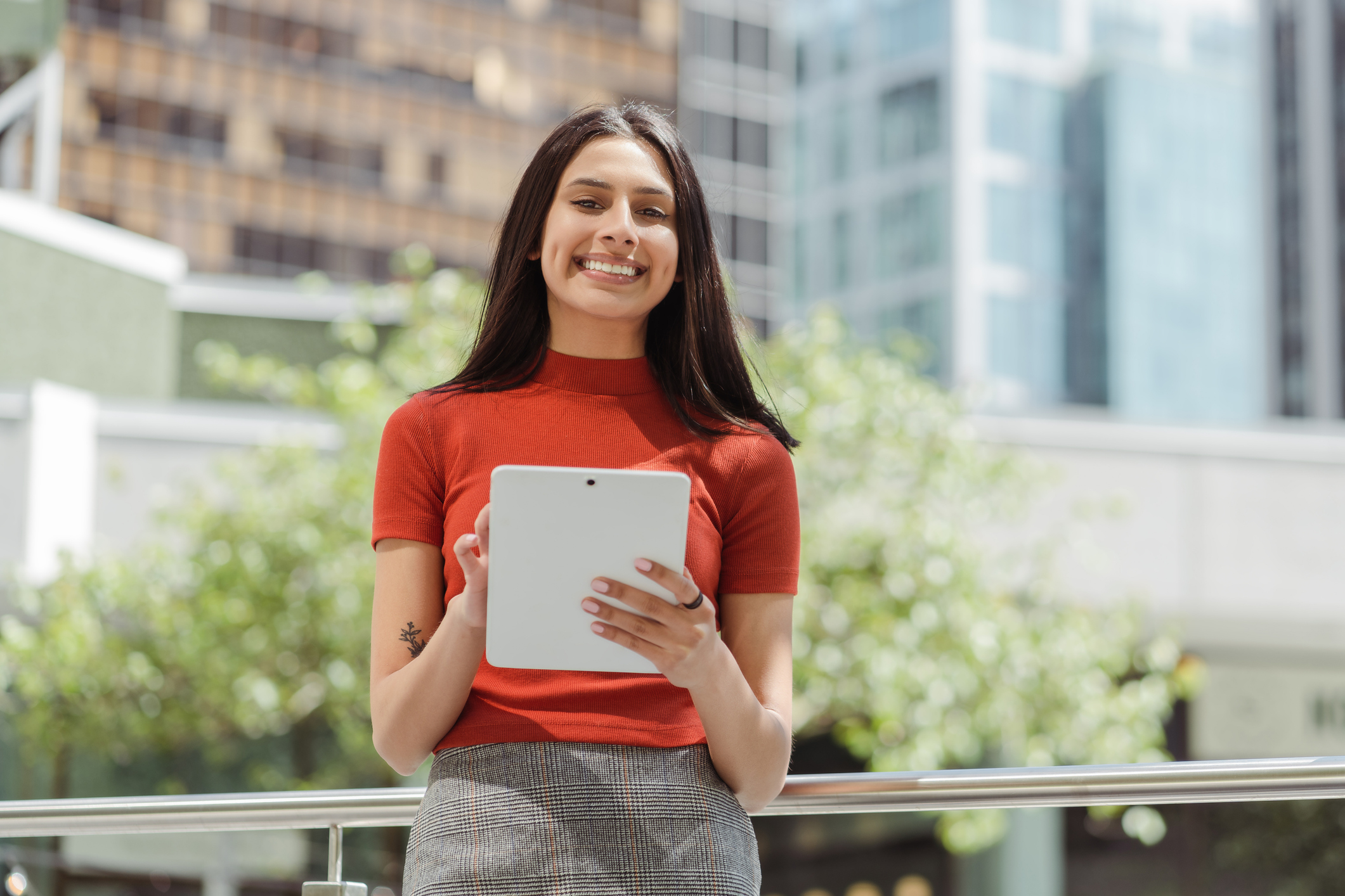 Portrait of a smiling woman holding a tablet